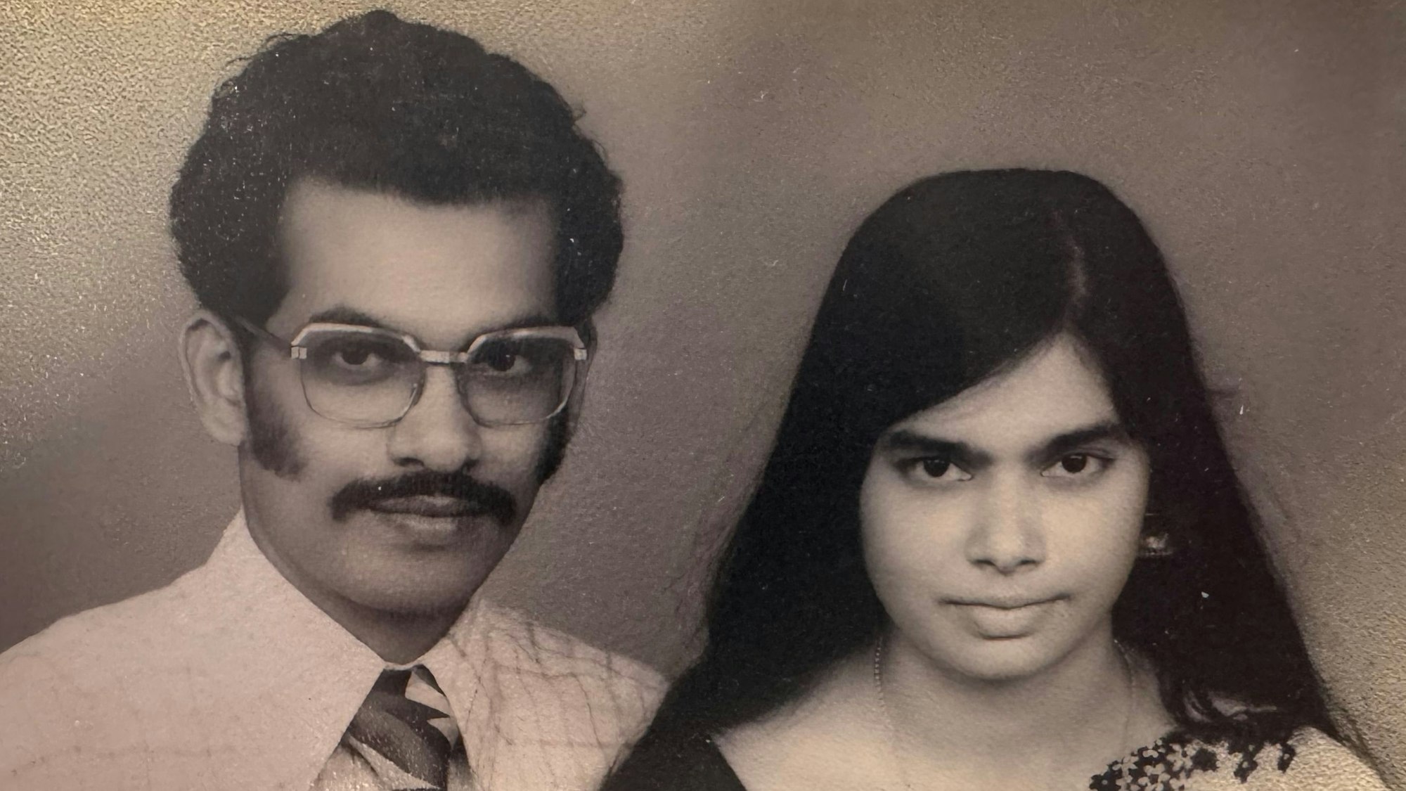 Zu sehen ist ein Ehepaar an seinem Hochzeitstag in schwarz-weiß.