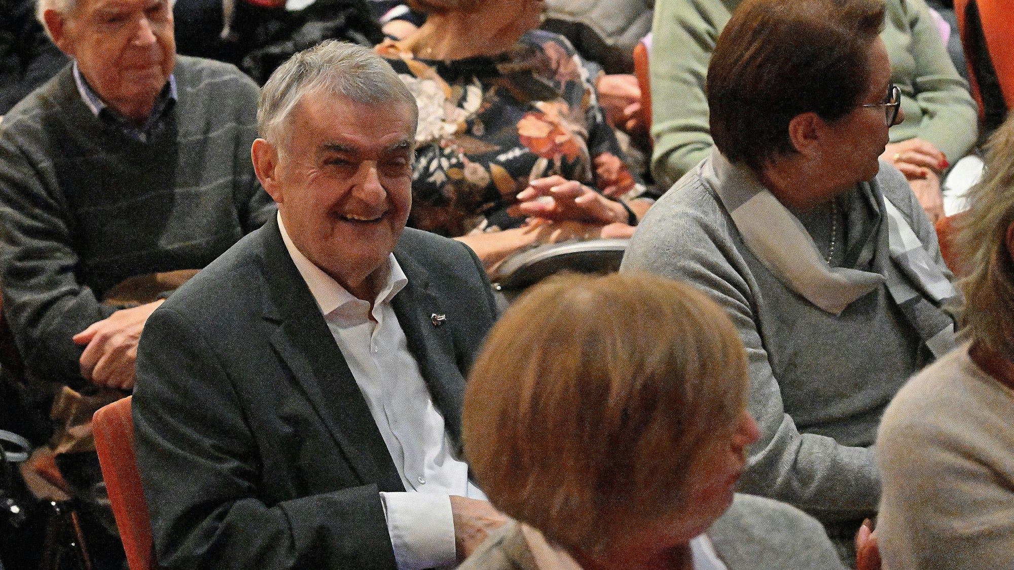 NRW-Innenminister Herbert Reul sitzt im Publikum und lacht.