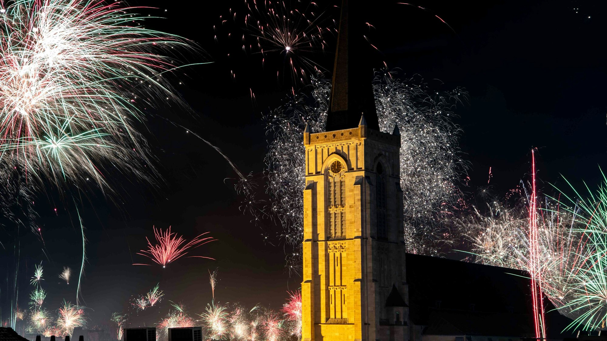 Das Bild zeigt Feuerwerk in der Silvesternacht an der Herz-Jesu-Kirche.