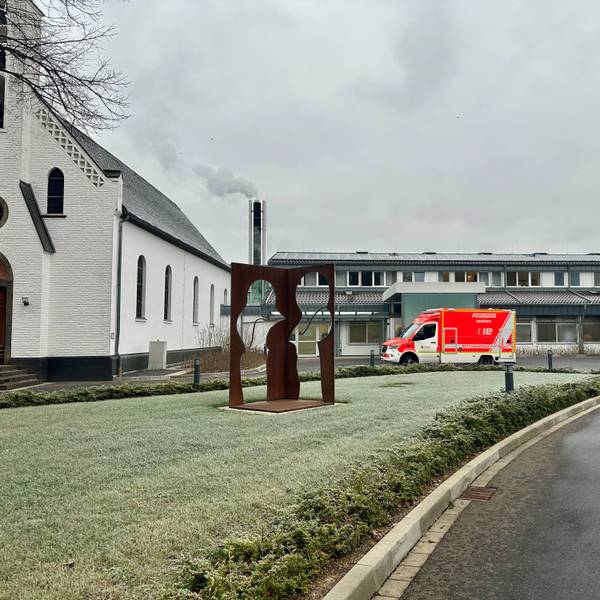 Das Bild zeigt das Krankenhaus und einen Rettungswagen.