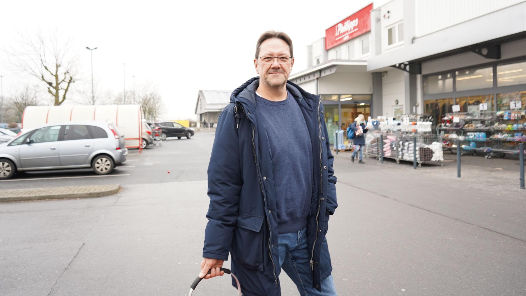 Das Foto zeigt einen Mann auf einem Parkplatz.