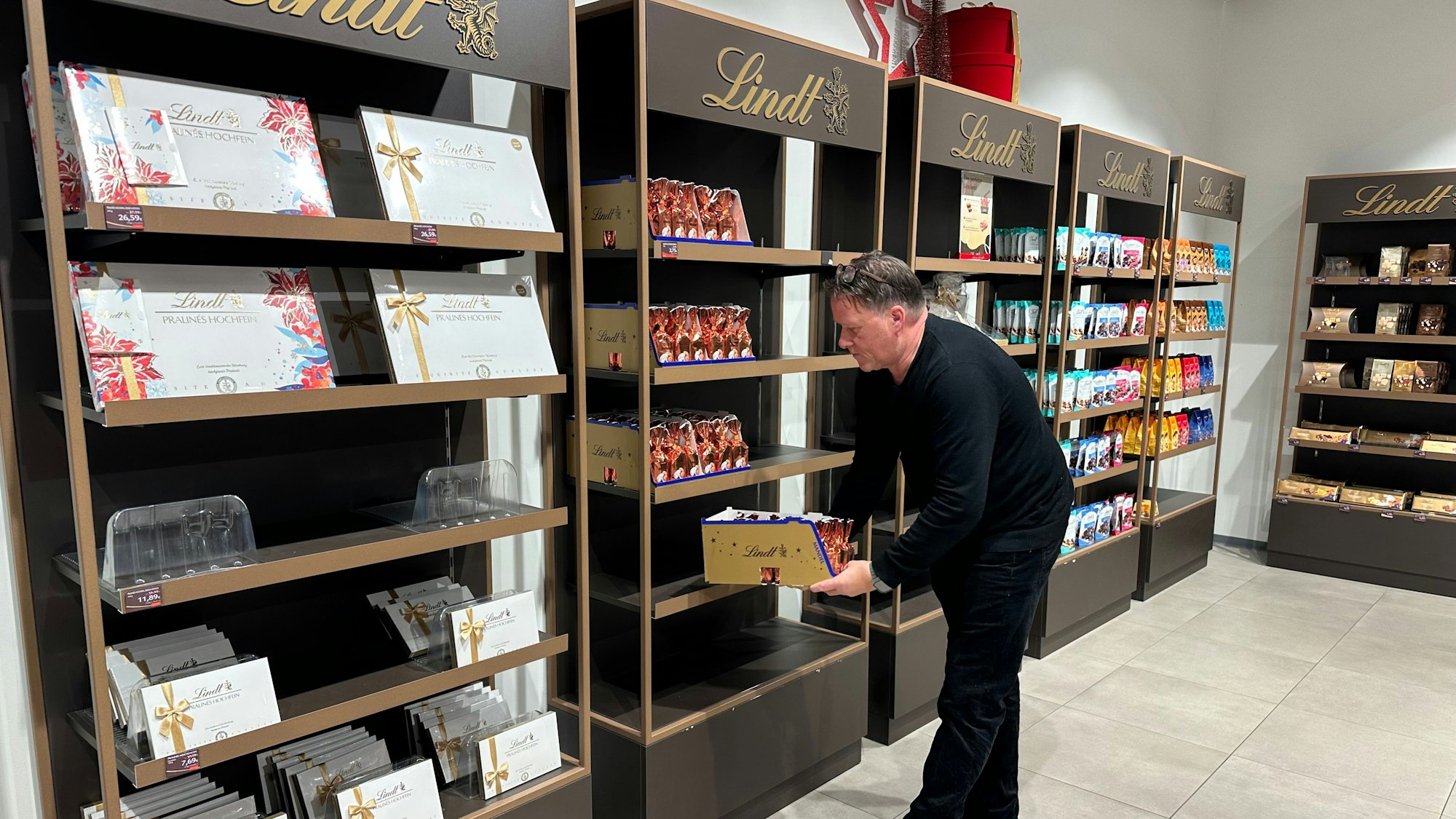 Leere Regale im Shop von Lindt auf der Outletebene nach dem erfolgreichen Weihnachtsgeschäft. Shop-Manager Sascha Leeser räumt Ware nach. Huma blickt auf ein erfolgreiches Jahr 2025 zurück