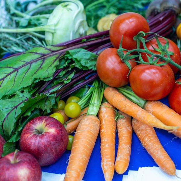 Gemüse und Obst wie Äpfel, Möhren, Trauben und Tomaten auf einem Haufen.