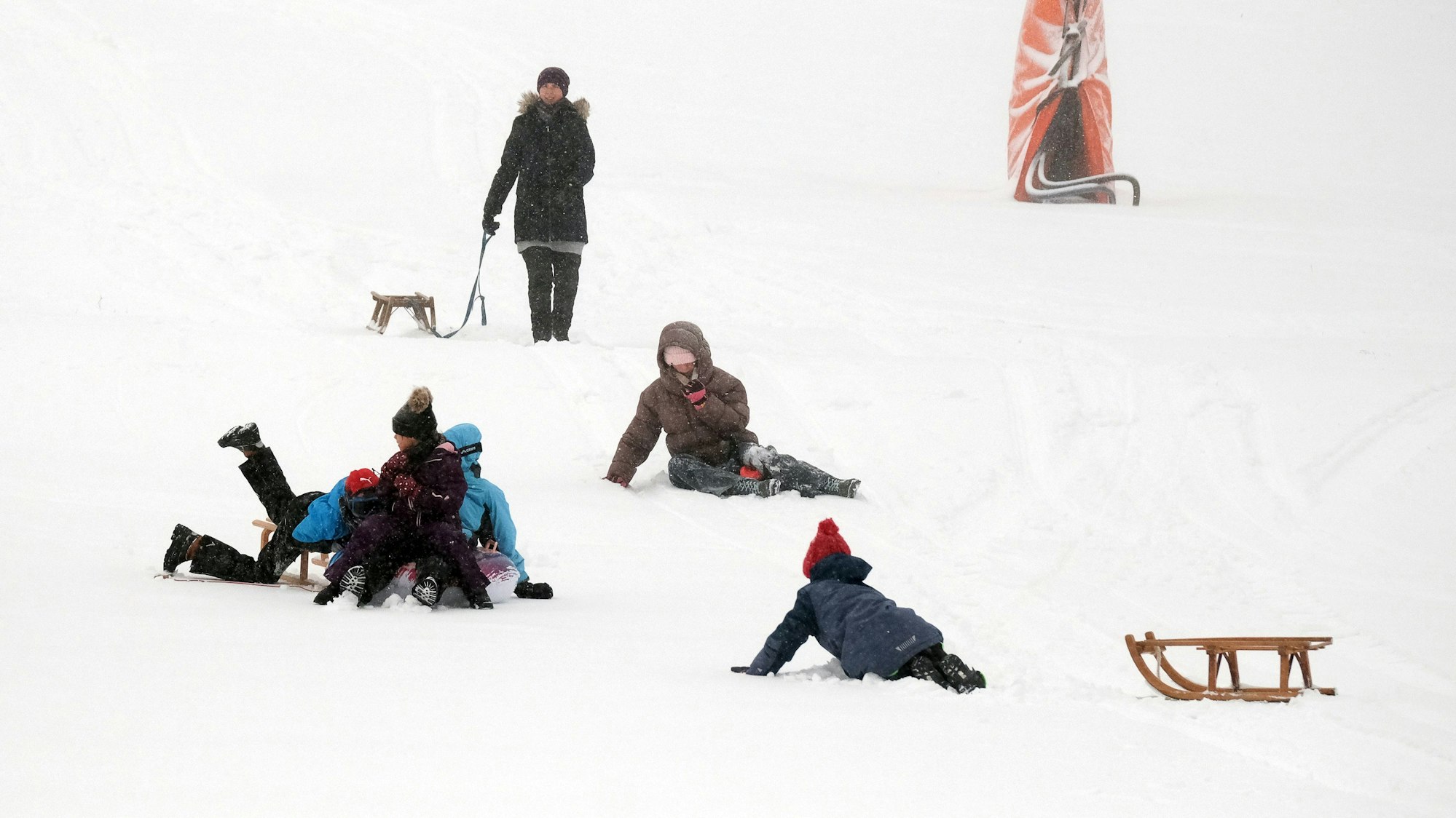 Beim Rodeln rasten zwei Kinder in eine Frau mit ihrem Kleinkind auf dem Arm. (Symbolbild)