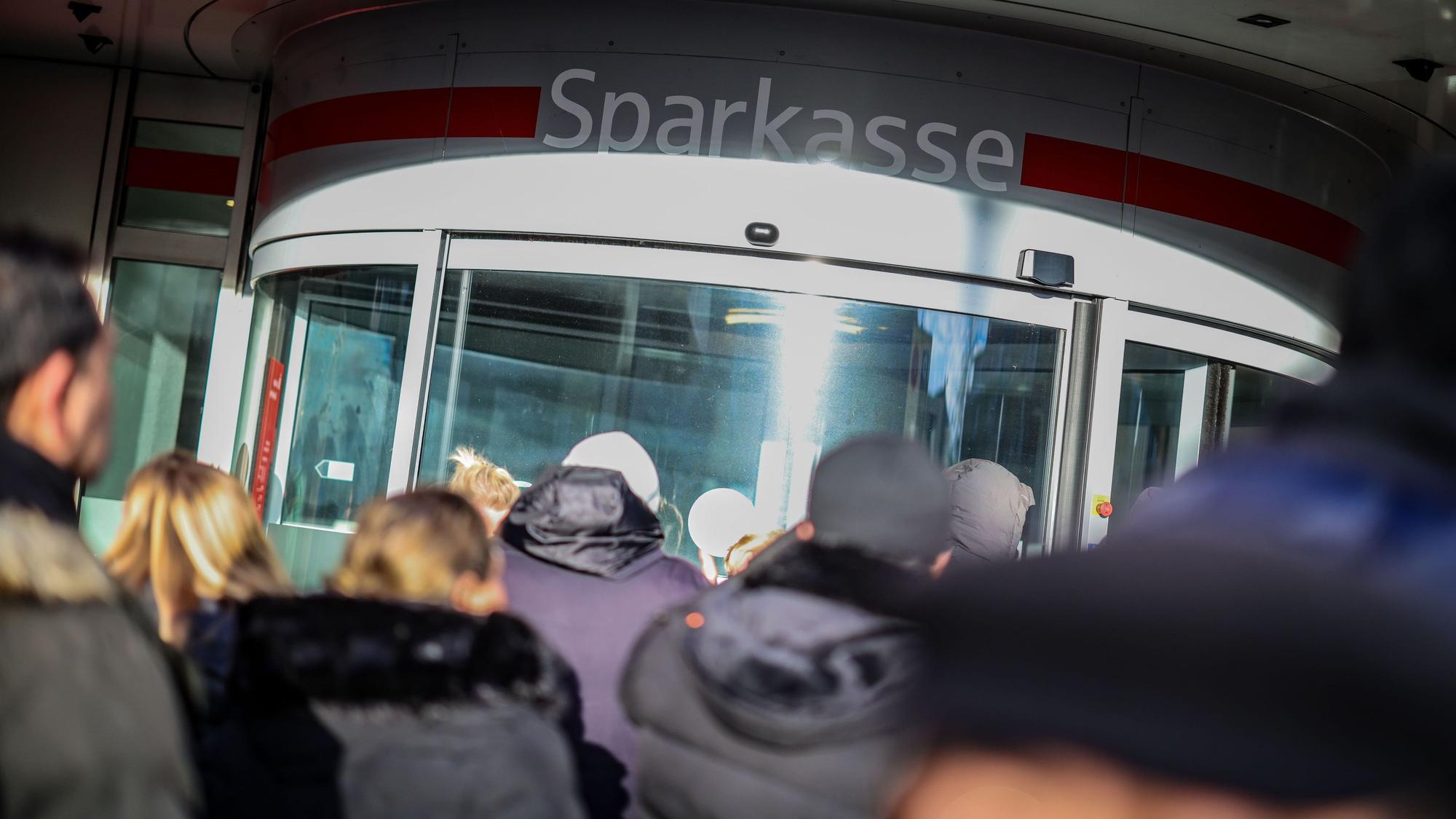 Wartenden Kunden stehen vor der Sparkassenfiliale in Gelsenkirchen-Buer, um Informationen zu ihren Schließfächern zu erhalten, nachdem in den Tresorraum der Bank eingebrochen wurde. (Archivbild)