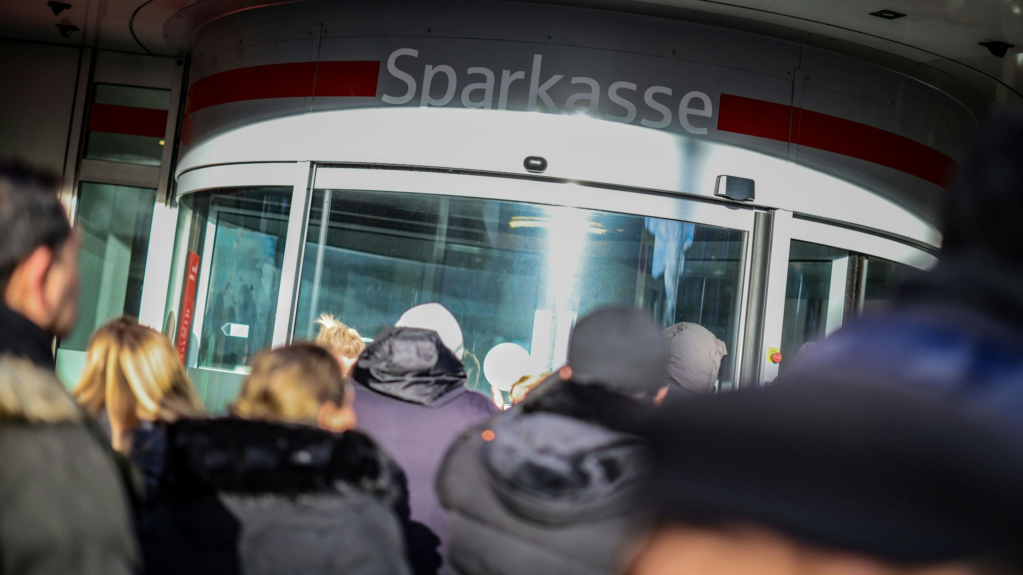 Wartenden Kunden stehen vor der Sparkassenfiliale in Gelsenkirchen-Buer, um Informationen zu ihren Schließfächern zu erhalten, nachdem in den Tresorraum der Bank eingebrochen wurde. (Archivbild)