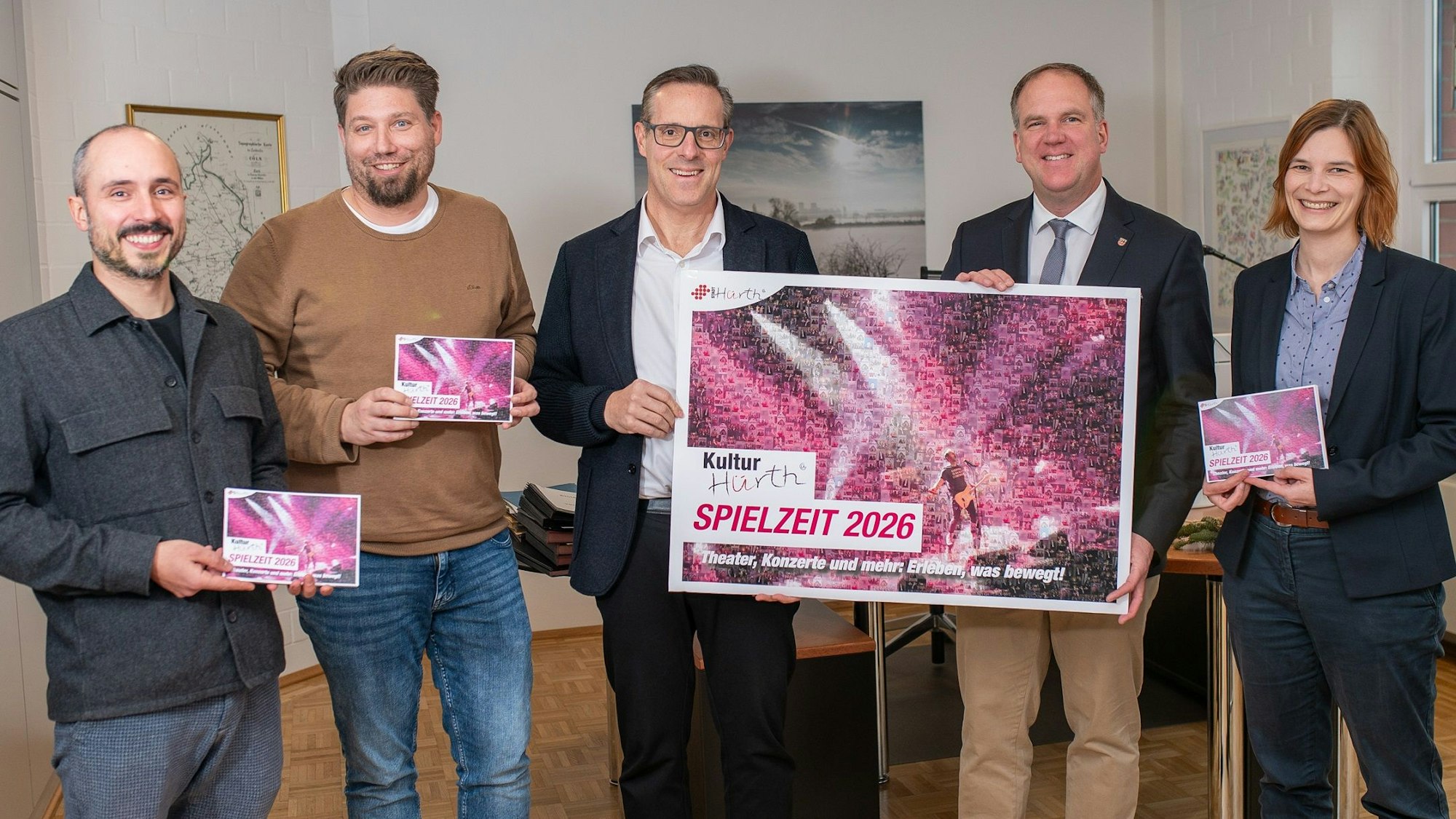 Vier Männer und eine Frau halten Plakate und Flyer.