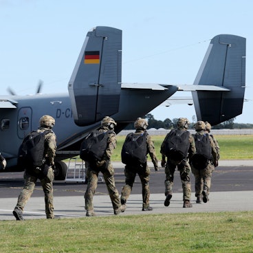 Das Bild zeigt Fallschirmjäger der Bundeswehr auf dem Weg zu einer Maschine. Foto: Bernd Wüstneck/dpa