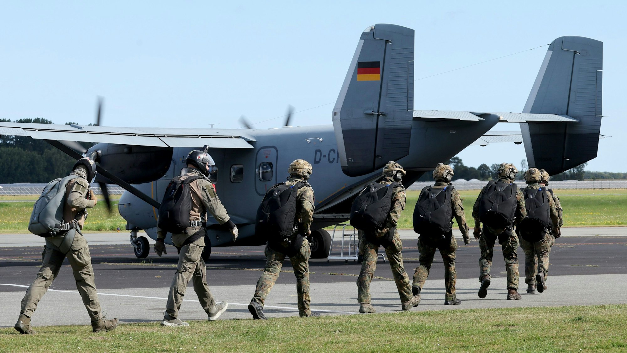 Das Bild zeigt Fallschirmjäger der Bundeswehr auf dem Weg zu einer Maschine. Foto: Bernd Wüstneck/dpa