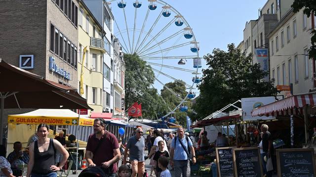Im Vordergrund Menschen, im Hintergrund ein Riesenrad
