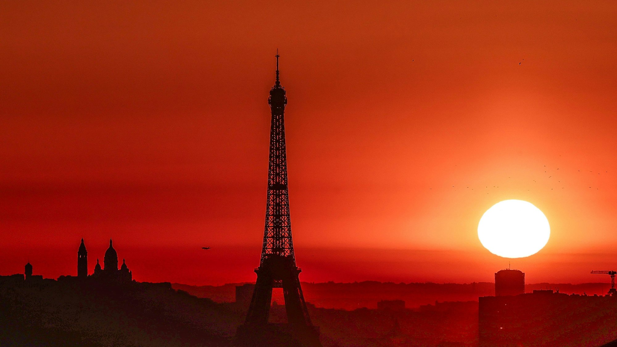 Die Sonne geht über dem Eiffelturm und der Basilika Sacre Coeur auf dem Montmartre-Hügel auf.