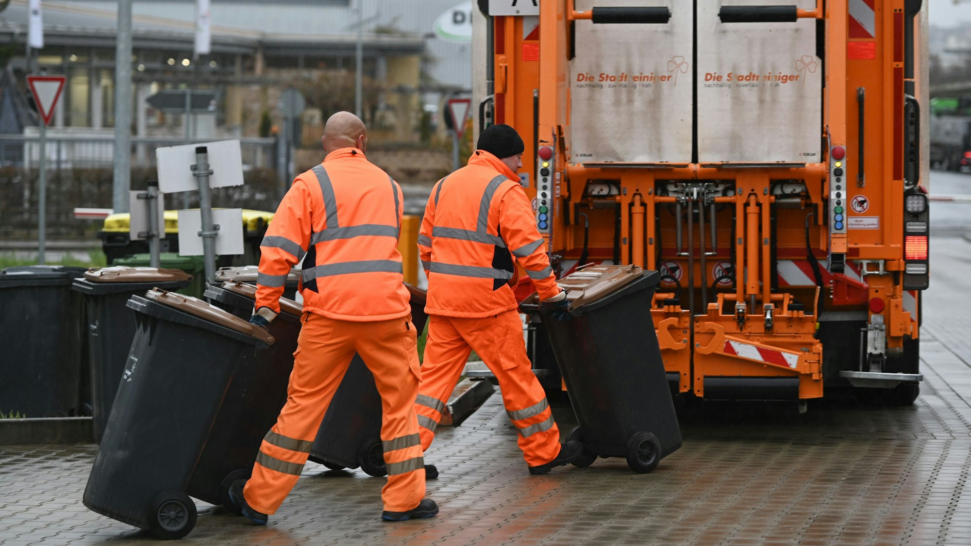 Zwei Stadtreiniger leeren Biotonnen.(Symbolfoto)