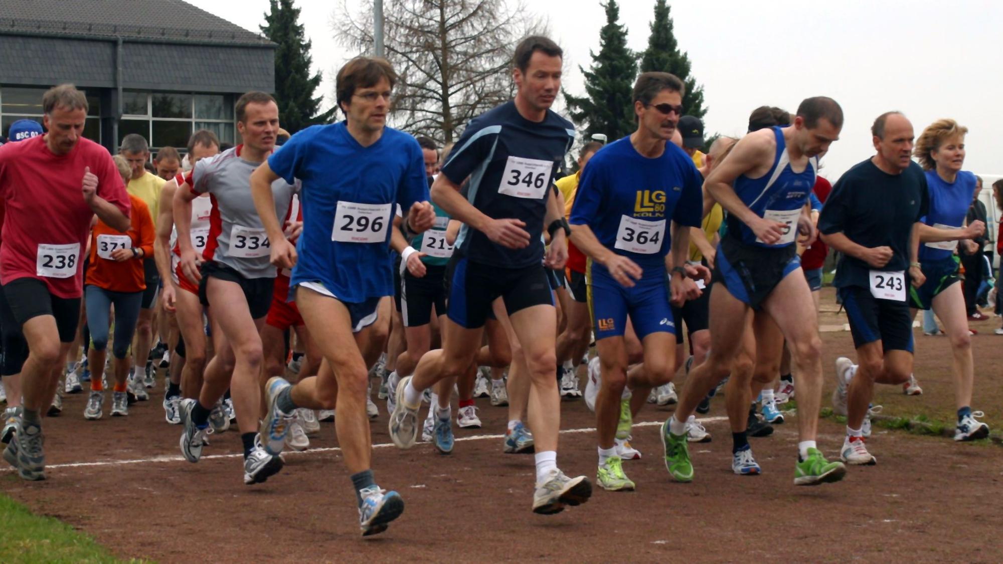 Männer und Frauen am Start einer Leichtathletikveranstaltung.