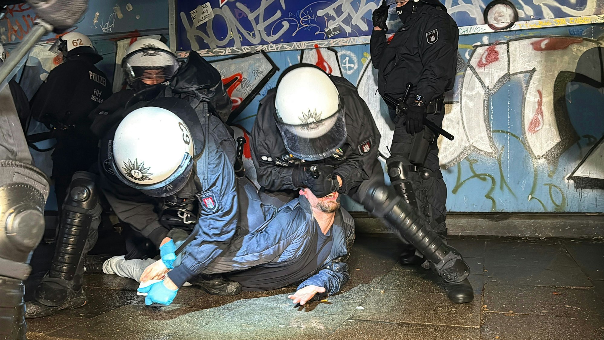 dpatopbilder - 31.12.2025, Hamburg: Einsatzkräfte der Polizei nehmen in der Silvesternacht eine Person im Hamburger Stadtteil Steilshoop in Gewahrsam. In Steilshoop wurden laut Polizei Passanten und Einsatzkräfte mit Pyrotechnik beworfen. Foto: Sebastian Peters/News5/dpa +++ dpa-Bildfunk +++