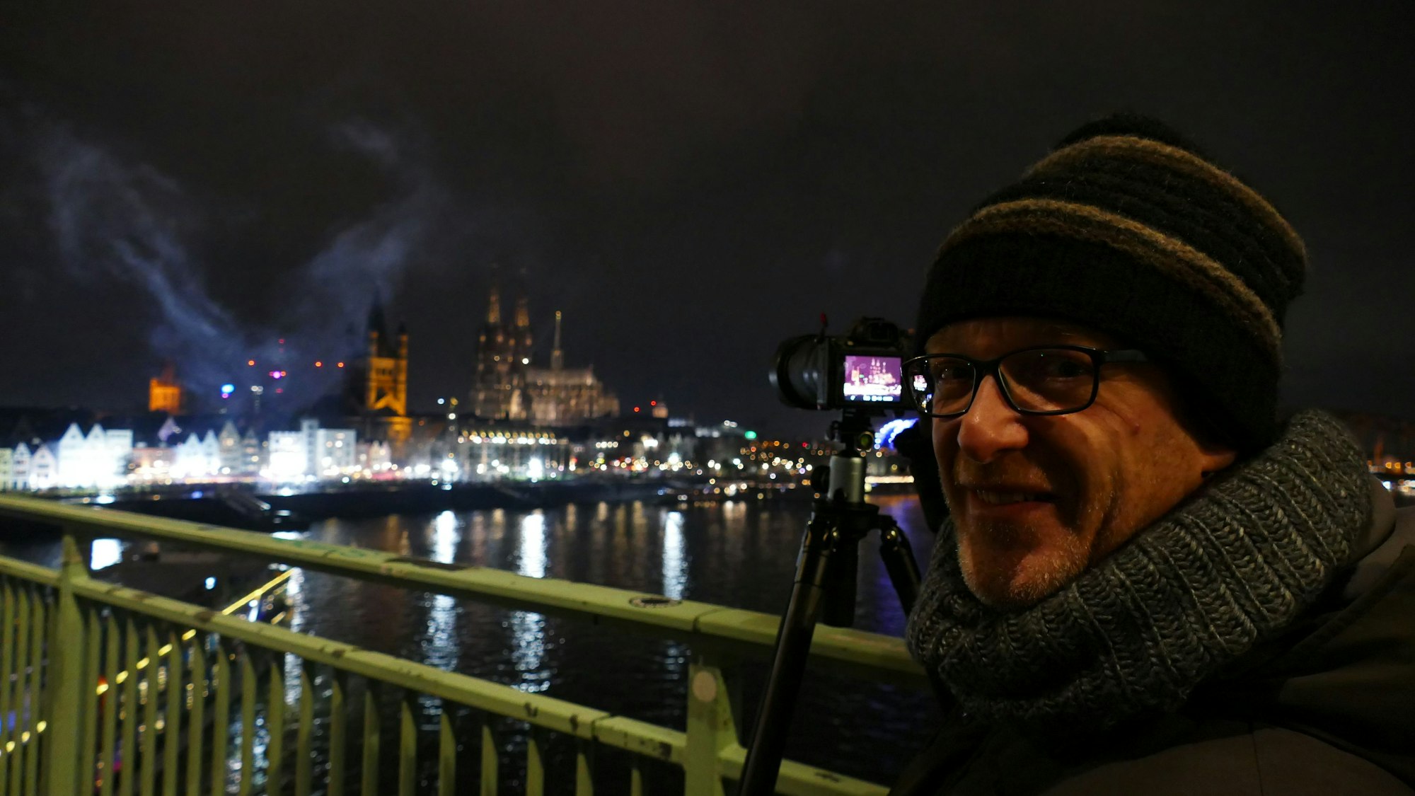 Frank Töpper aus Köln-Deutz fotografiert mit seiner Kamera das Feuerwerk mit der Dom-Kulisse.