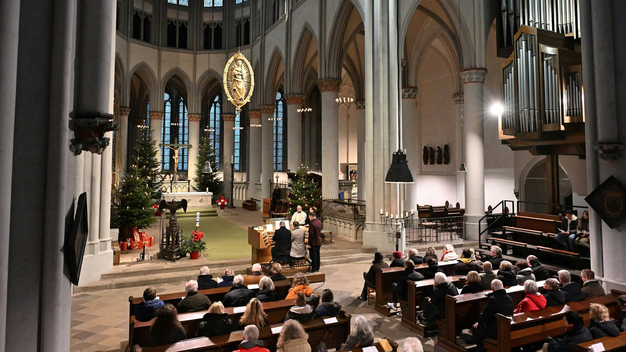 Der Altenberger Dom von innen mit zahlreichen Gästen auf den Bänken und zwei Organisten, festlich geschmückt.