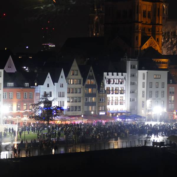 31.12.2025: Menschen stehen gegen 23 Uhr am Kölner Rheinufer, das sich stetig füllt.