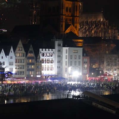 31.12.2025: Menschen stehen gegen 23 Uhr am Kölner Rheinufer, das sich stetig füllt.