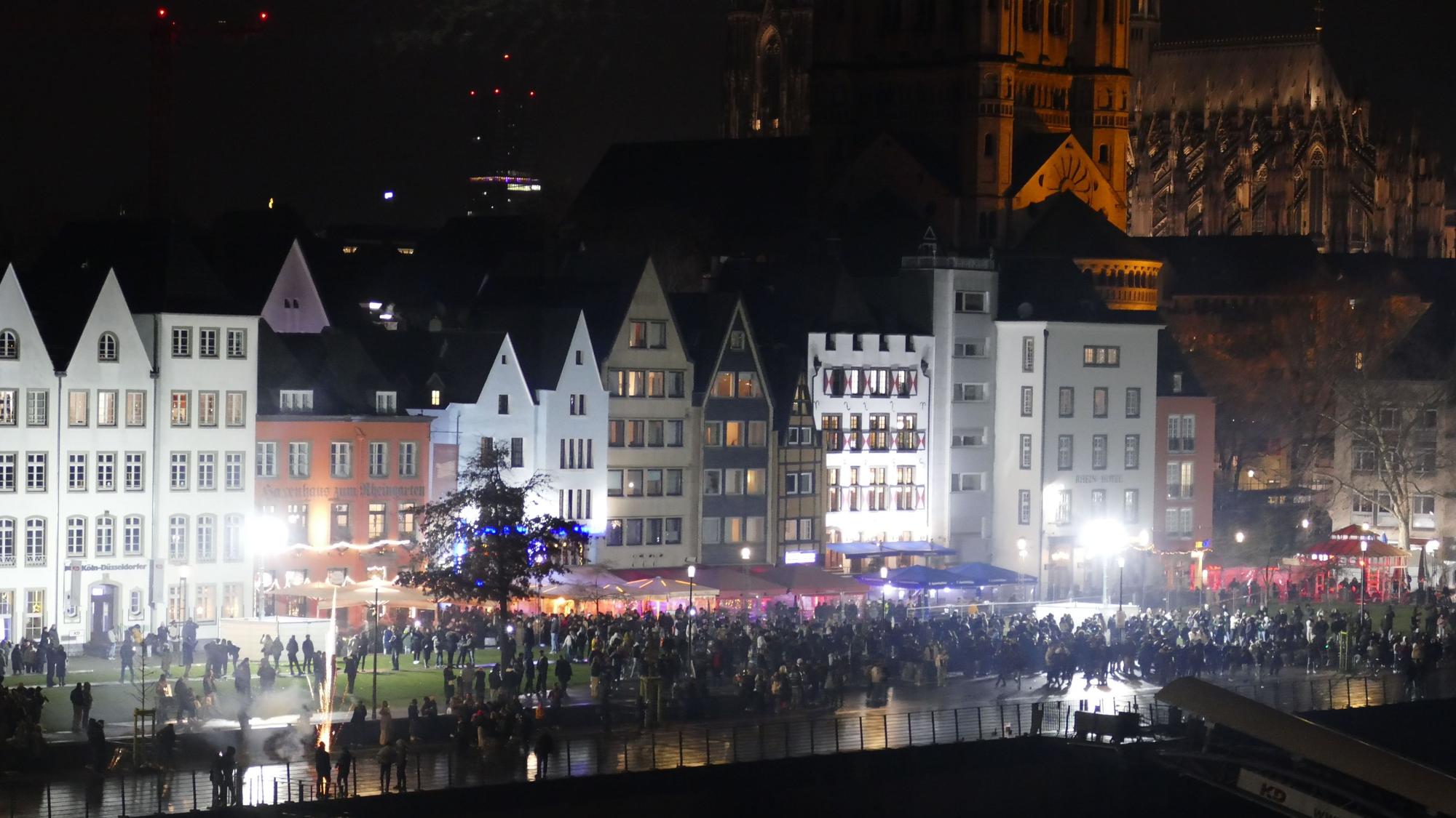 31.12.2025: Menschen stehen gegen 23 Uhr am Kölner Rheinufer, das sich stetig füllt.