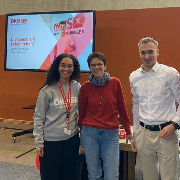 Salome Steinhoff, Birgit Karsten, Tim Förster und Klaus Drotbohm stehen nebeneinander. Links hinter ihnen ist ein Plakat der DKMS zu sehen.