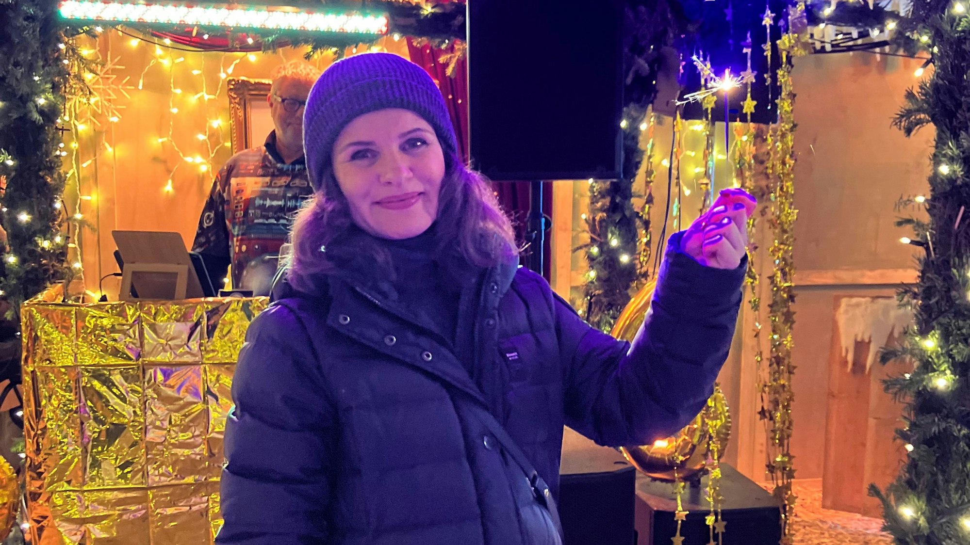 Iris Weiss hält eine brennende Wunderkerze in der Hand.