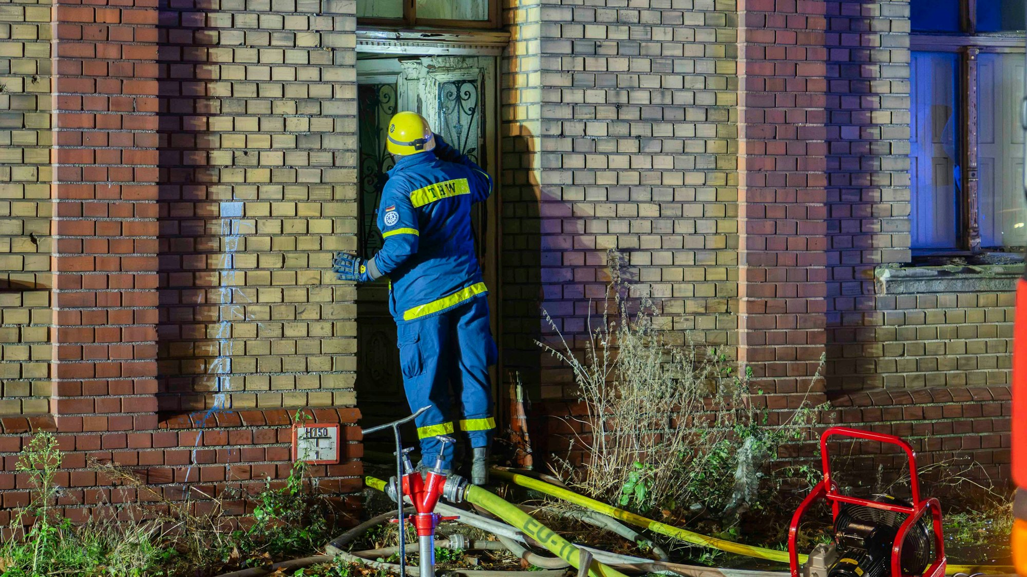Das Bild zeigt einen Mitarbeiter des THW Euskirchen, der einen Blick durch die Eingangstür wirft.
