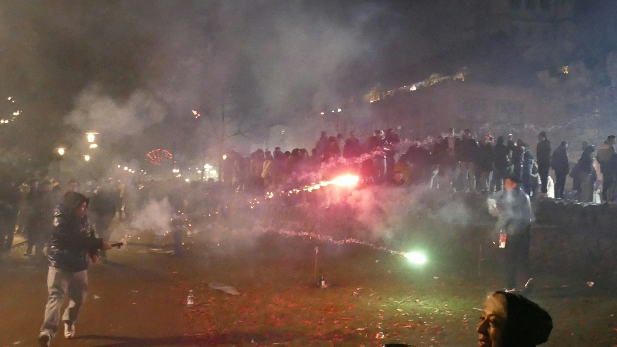 Zwei Personen schießen sich am Kölner Rheinufer mit Feuerwerk ab.