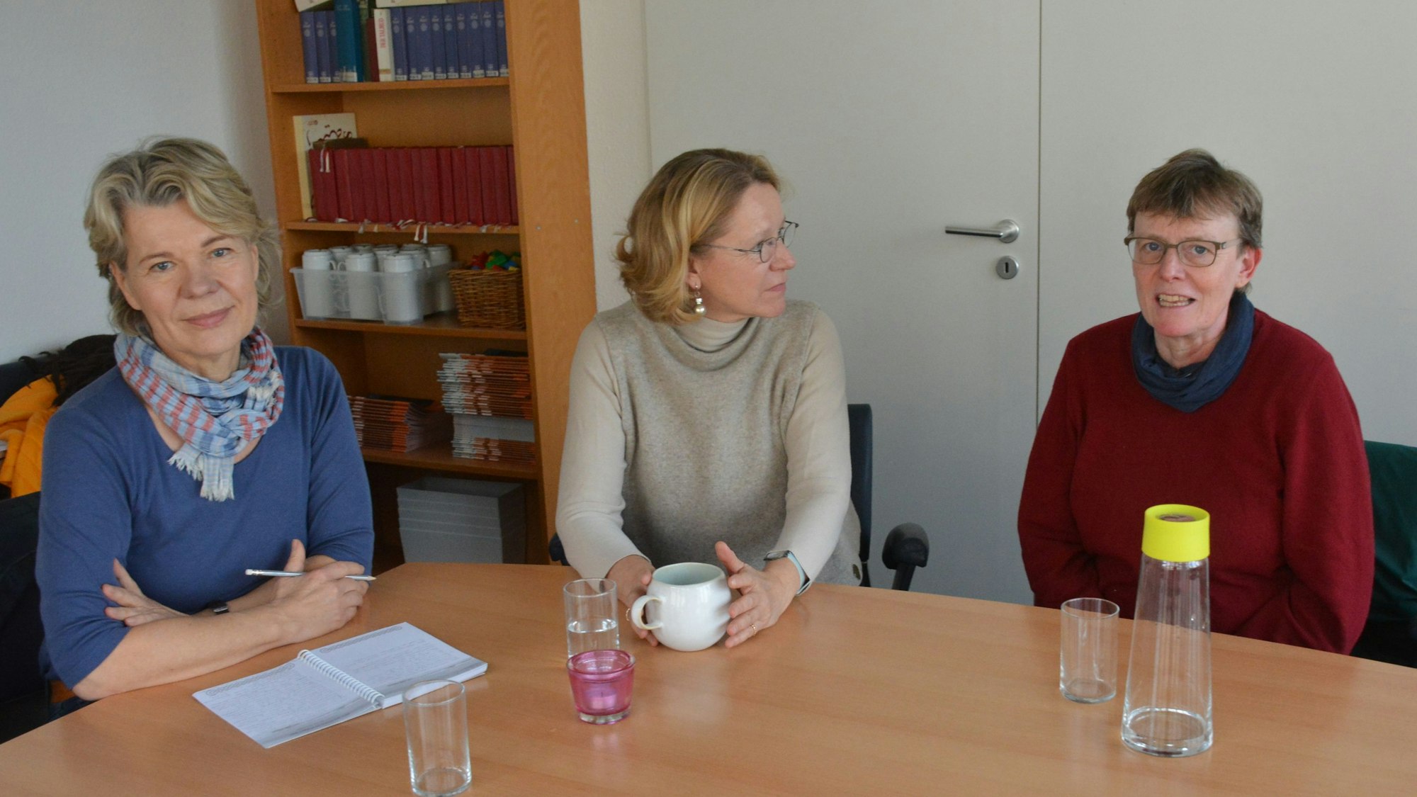 Drei Frauen sitzen an einem Tisch.