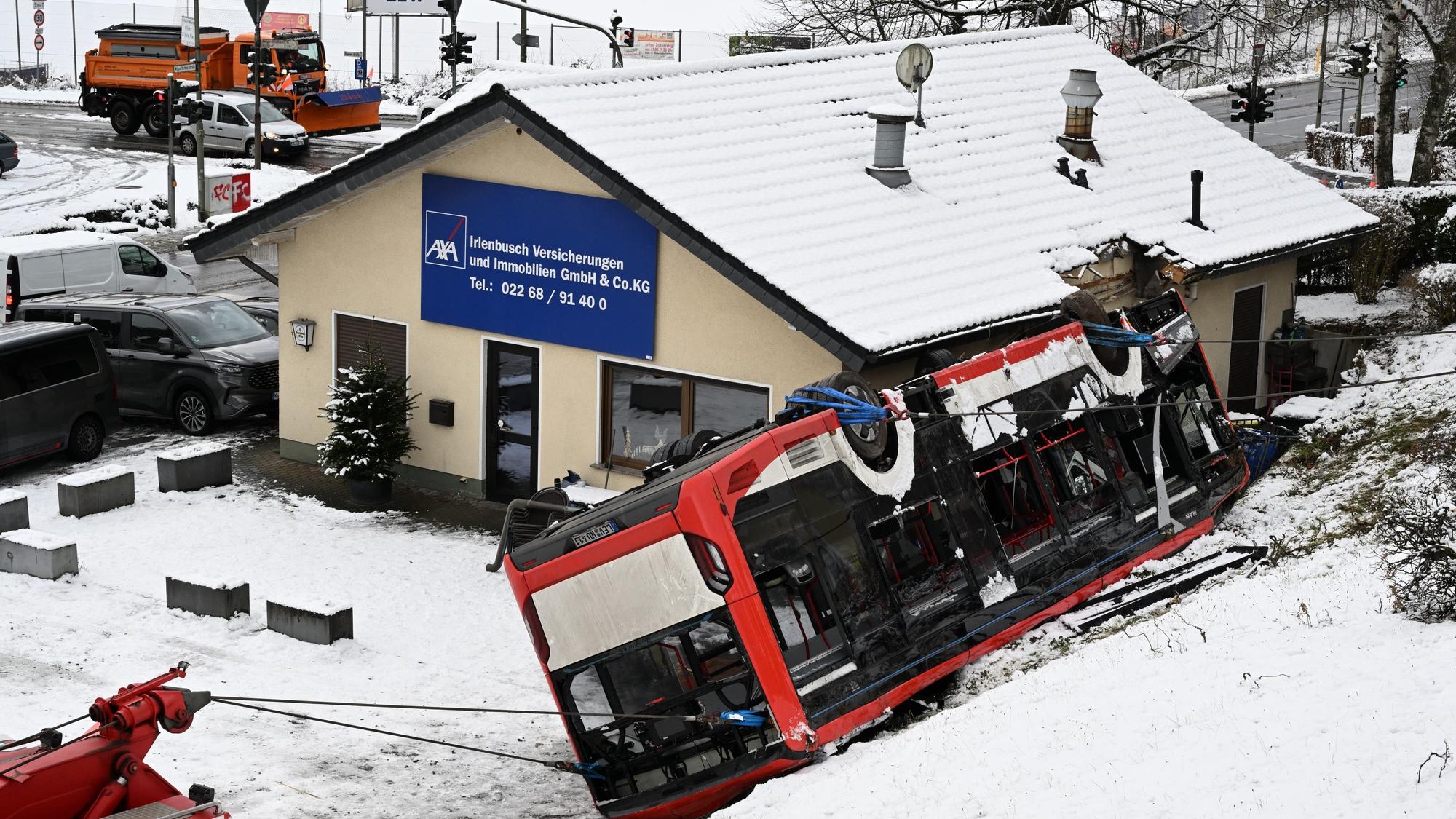 Der Bus liegt auf dem Dach und hat sich in das Gebäude verkeilt.
