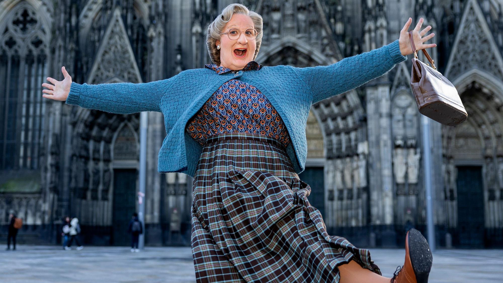 Das Bild zeigt Thomas Hohler als Mrs. Doubtfire verkleidet vor dem Kölner Dom.