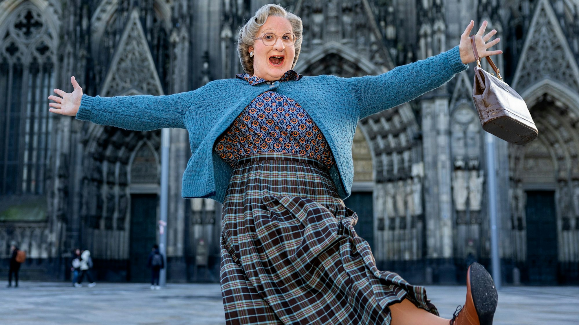 Das Bild zeigt Thomas Hohler als Mrs. Doubtfire verkleidet vor dem Kölner Dom.