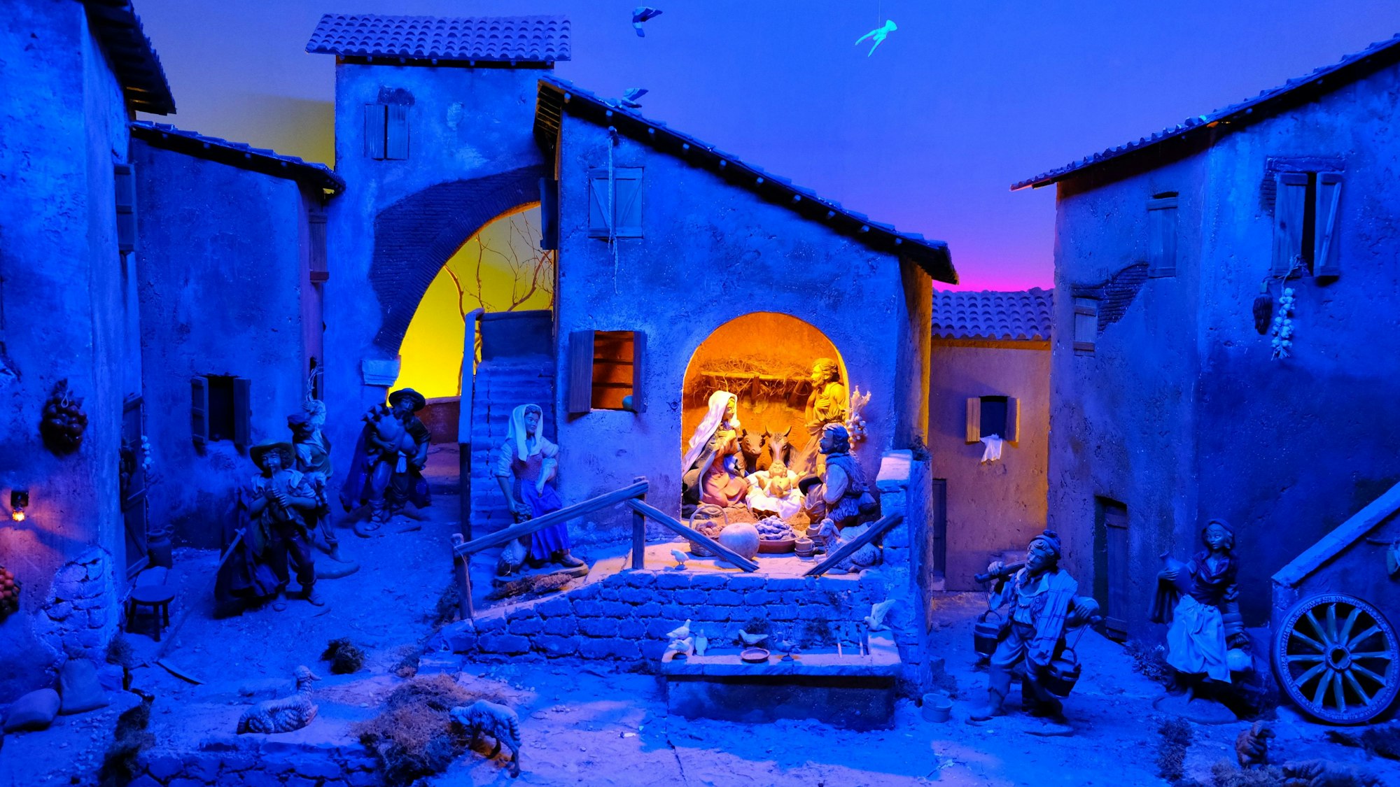 In dieser Krippendarstellung ist die Szenerie in abendlich blaues Licht getaucht, der Stall mit der Familie ist heller erleuchtet.