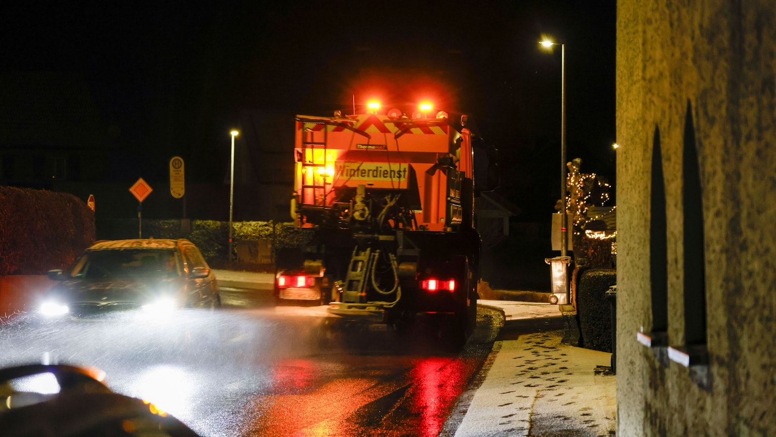 Ein Streu- und Räumfahrzeug des Winterdienst fährt auf einer Straße