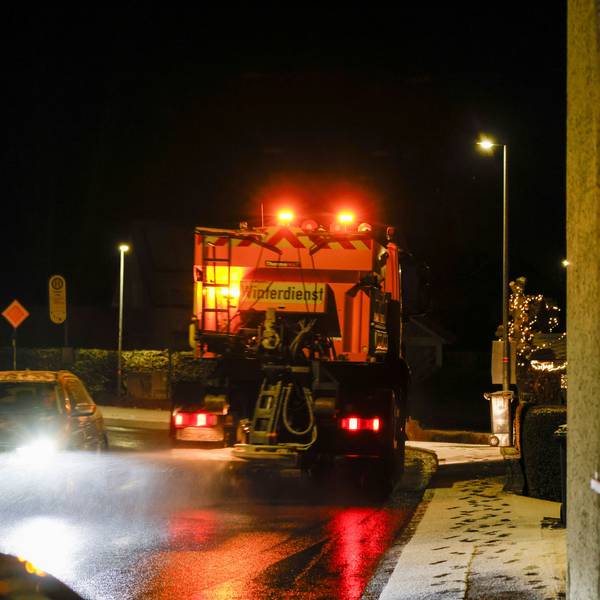 Ein Streu- und Räumfahrzeug des Winterdienst fährt auf einer Straße