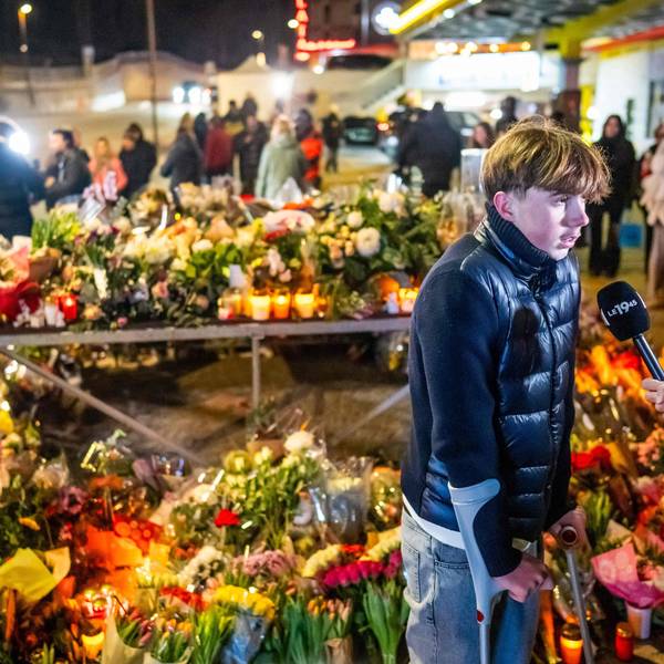 Ein junger Überlebender der Feuerkatastrophe spricht vor einem Blumenmeer in Crans-Montana mit Journalisten.
