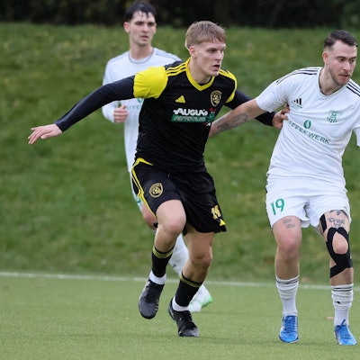 Das Foto zeigt einen Lechenicher Fußballer und einen Horremer, beide blicken dem Ball hinterher.