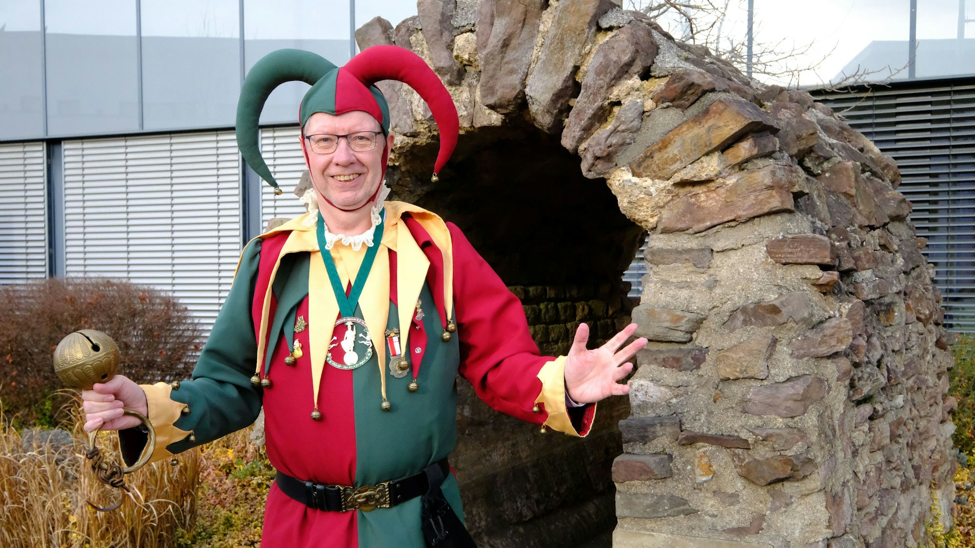 Dirk Gemünd aus Mechernich steht in seinem Kostüm als Kölner Bellejeck vor dem Römerkanal-Denkmal am Mechernicher Rathaus.