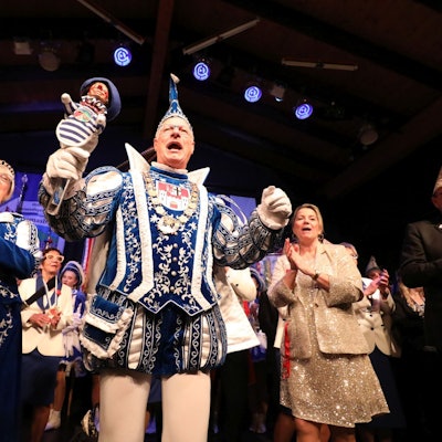 Ein Prinzenpaar in vollem Ornat auf einer Bühne.