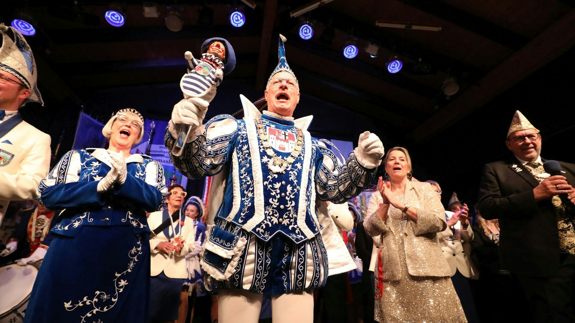 Ein Prinzenpaar in vollem Ornat auf einer Bühne.