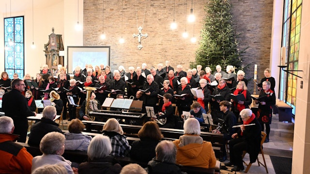 Der Kirchenchor singt vor einem Publikum in einer Kirche.