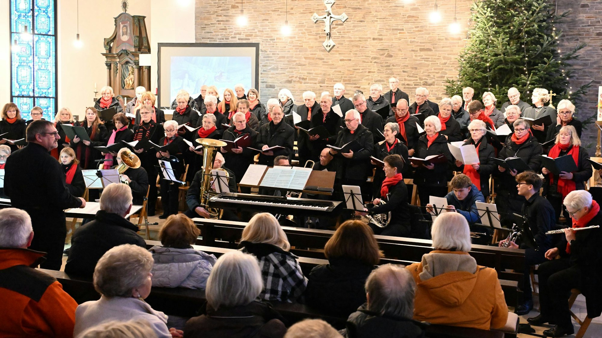 Der Kirchenchor singt vor einem Publikum in einer Kirche.