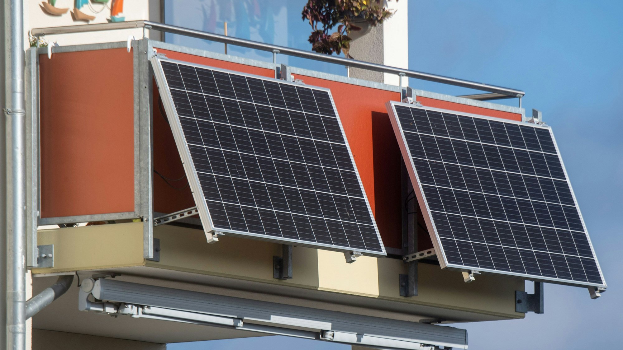 Solarmodule für ein sogenanntes Balkonkraftwerk hängen an einem Balkon.
