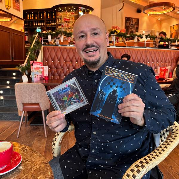 Ein Mann hält ein Buch und eine CD in seinen Händen.