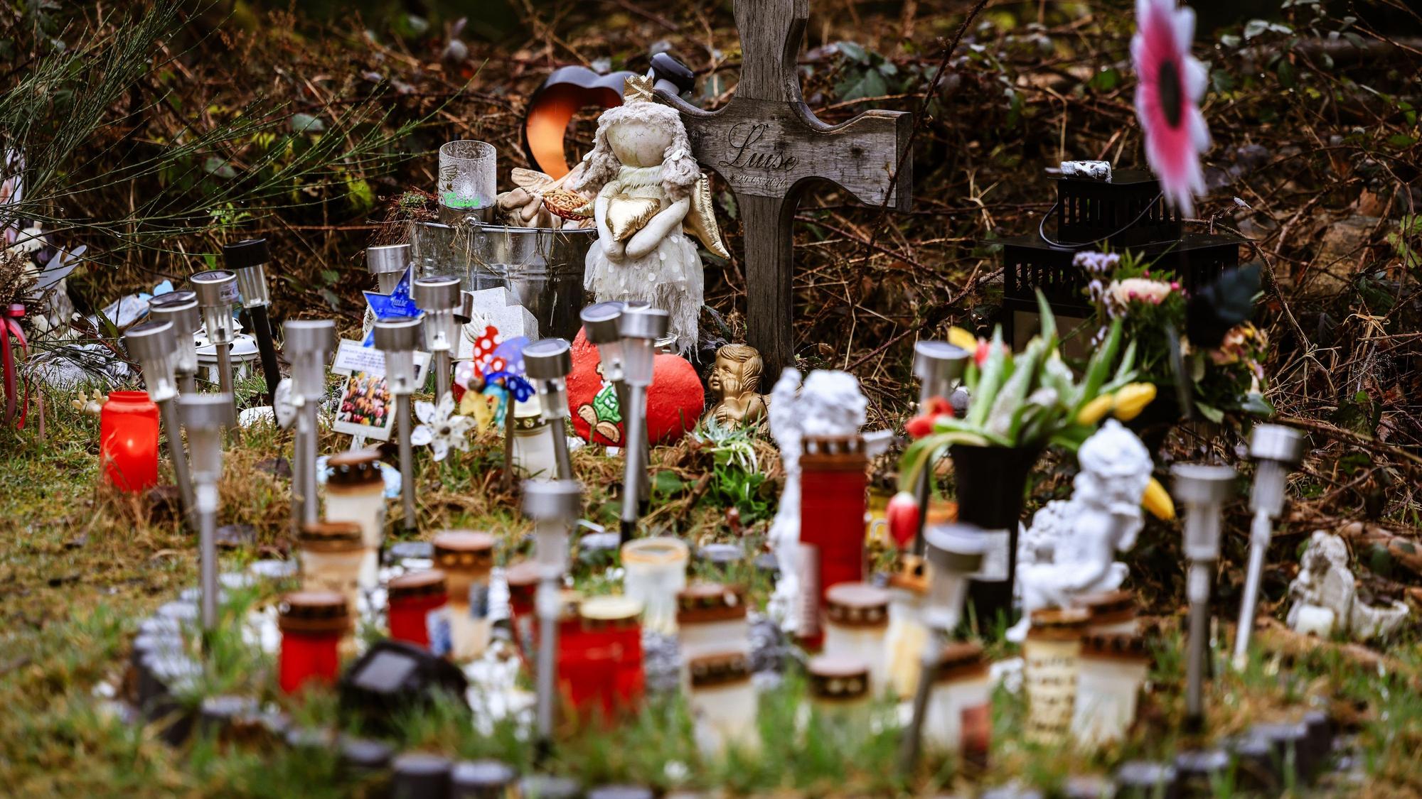 Kerzen, Blumen und Figuren liegen am Fundort an der Landesgrenze zwischen Rheinland-Pfalz und Nordrhein-Westfalen. Foto: Oliver Berg/dpa