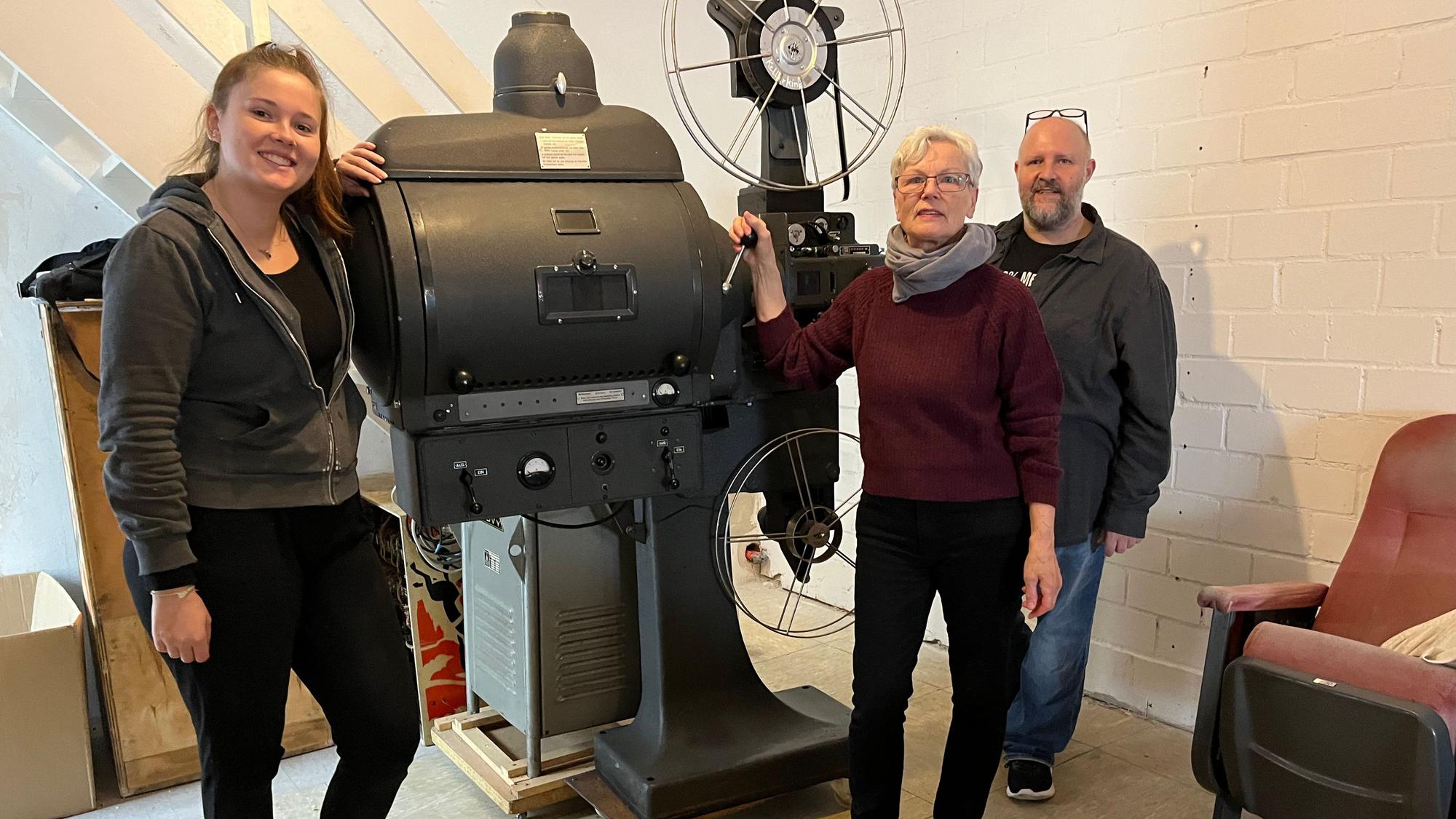 Das Foto zeigt Menschen bei einem Kino-Projektor.