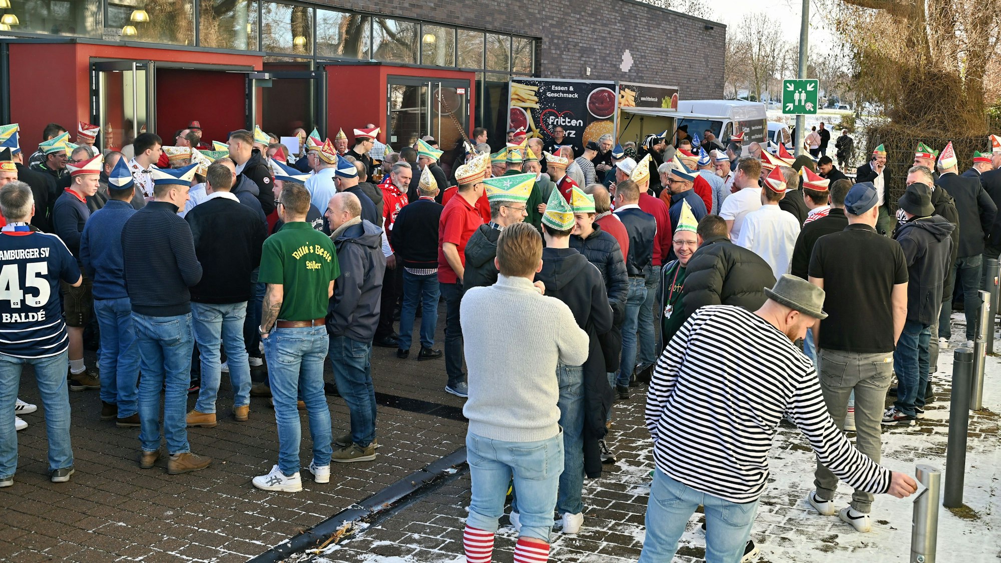 Männer, teils in Karnevalsuniform, stehen vor dem Zülpicher Forum.