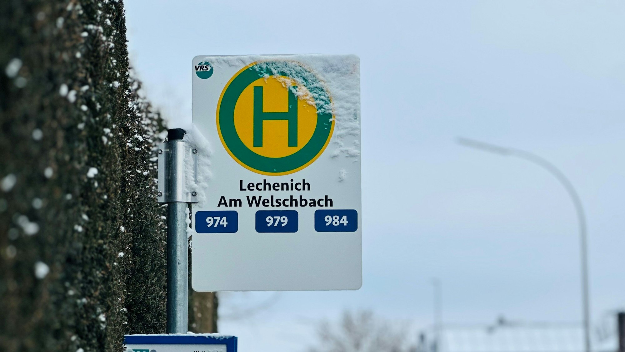 Zu sehen ist ein Haltestellenschild an einer Straße.