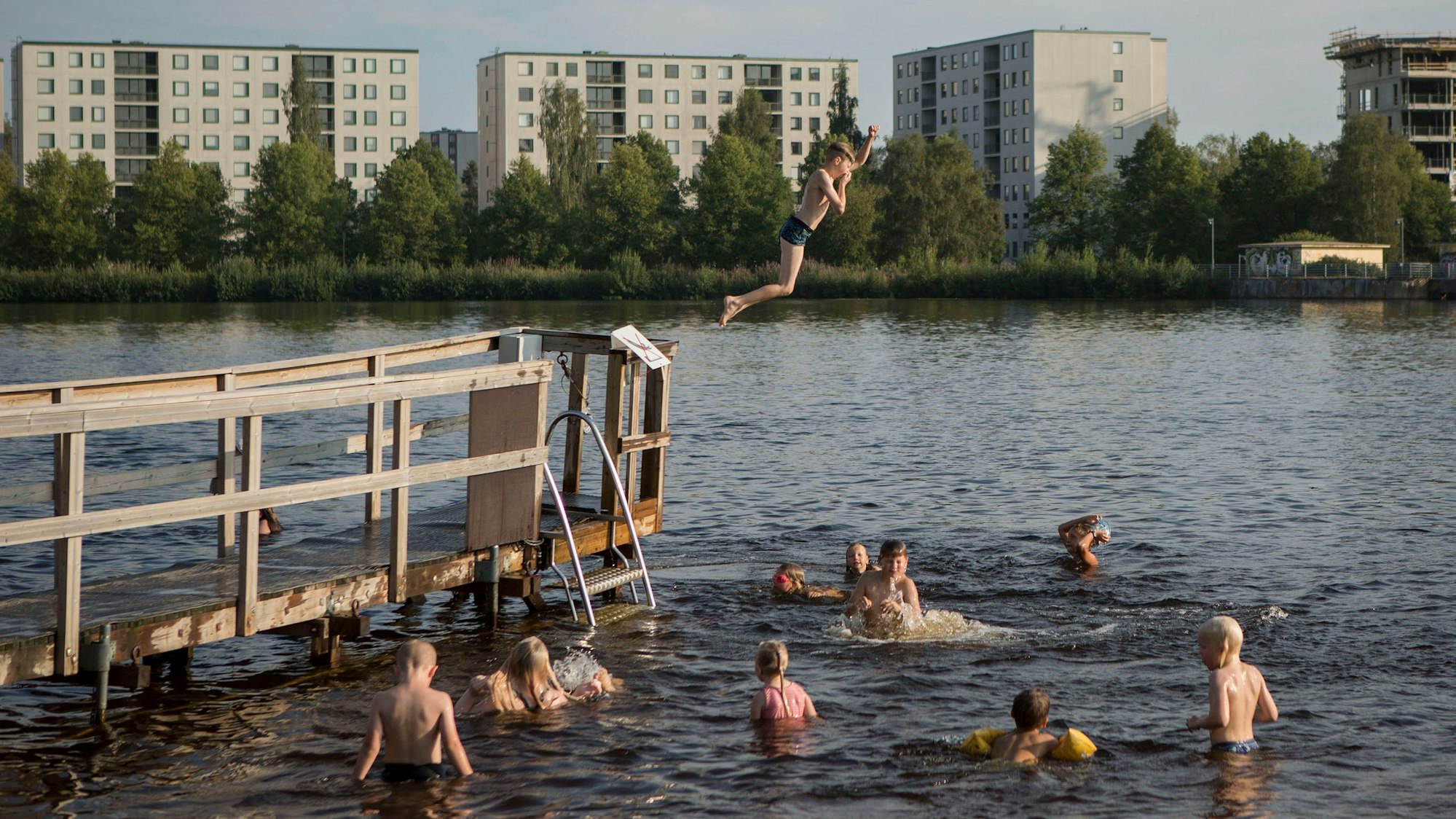 Menschen in Oulu springen in einen See.