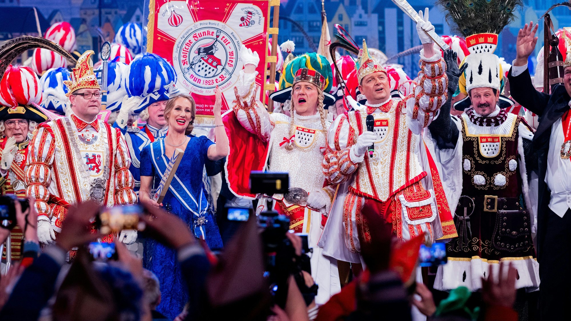 Das Düsseldorfer Prinzenpaar Prinz Dirk II. (l) und Venetia Uasa (l) und das Kölner Dreigstirn Prinz Boris I. (2.v.r., Boris Müller), Bauer Marco (r, Marco Schneefeld) und Jungfrau Agrippina (m, André Fahnenbruck) stehen bei der ersten „Alaaf & Helau-Sitzung“ im Gürzenich auf der Bühne.