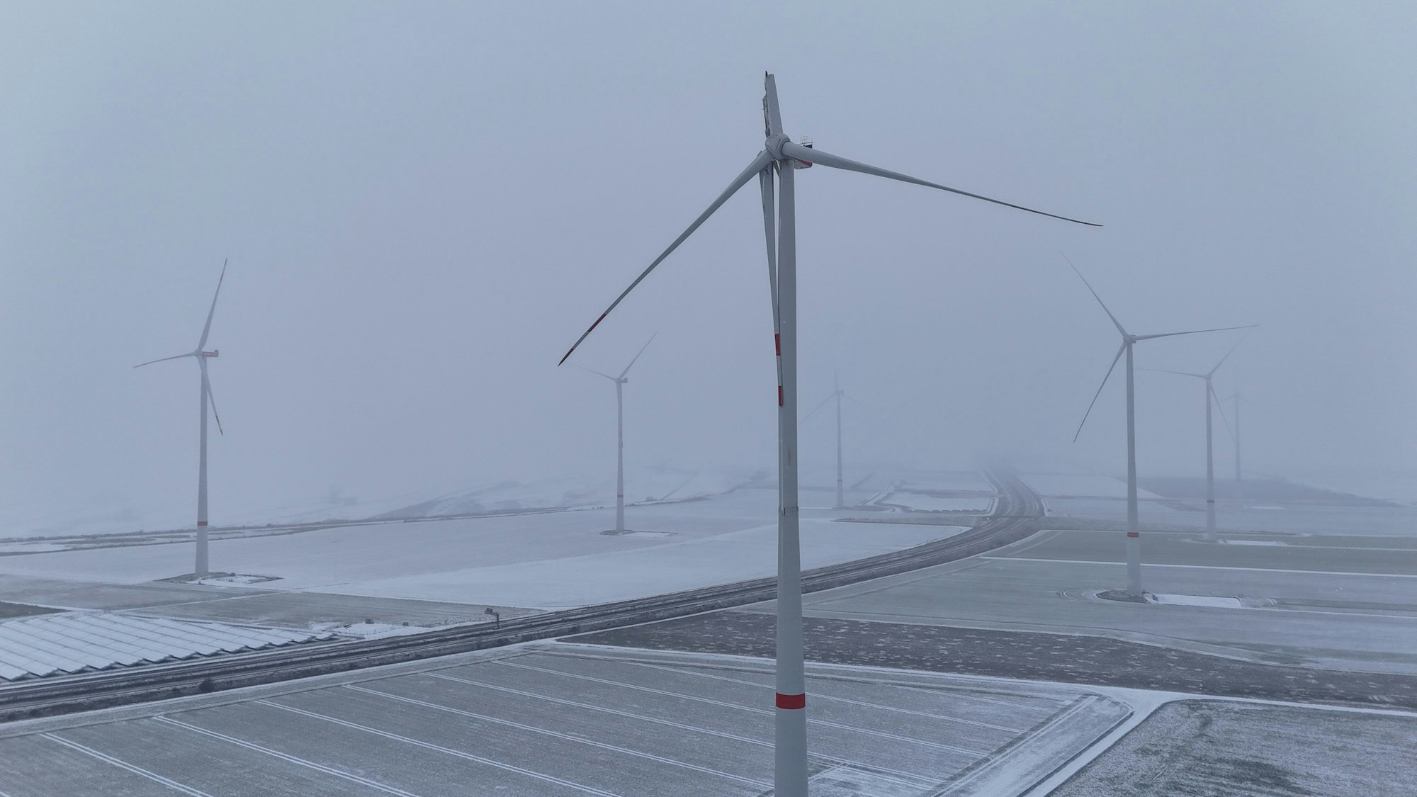 Das Drohnenfoto zeigt das defekte Windrad, im Hintergrund weitere Windräder und die verschneite Gegend.